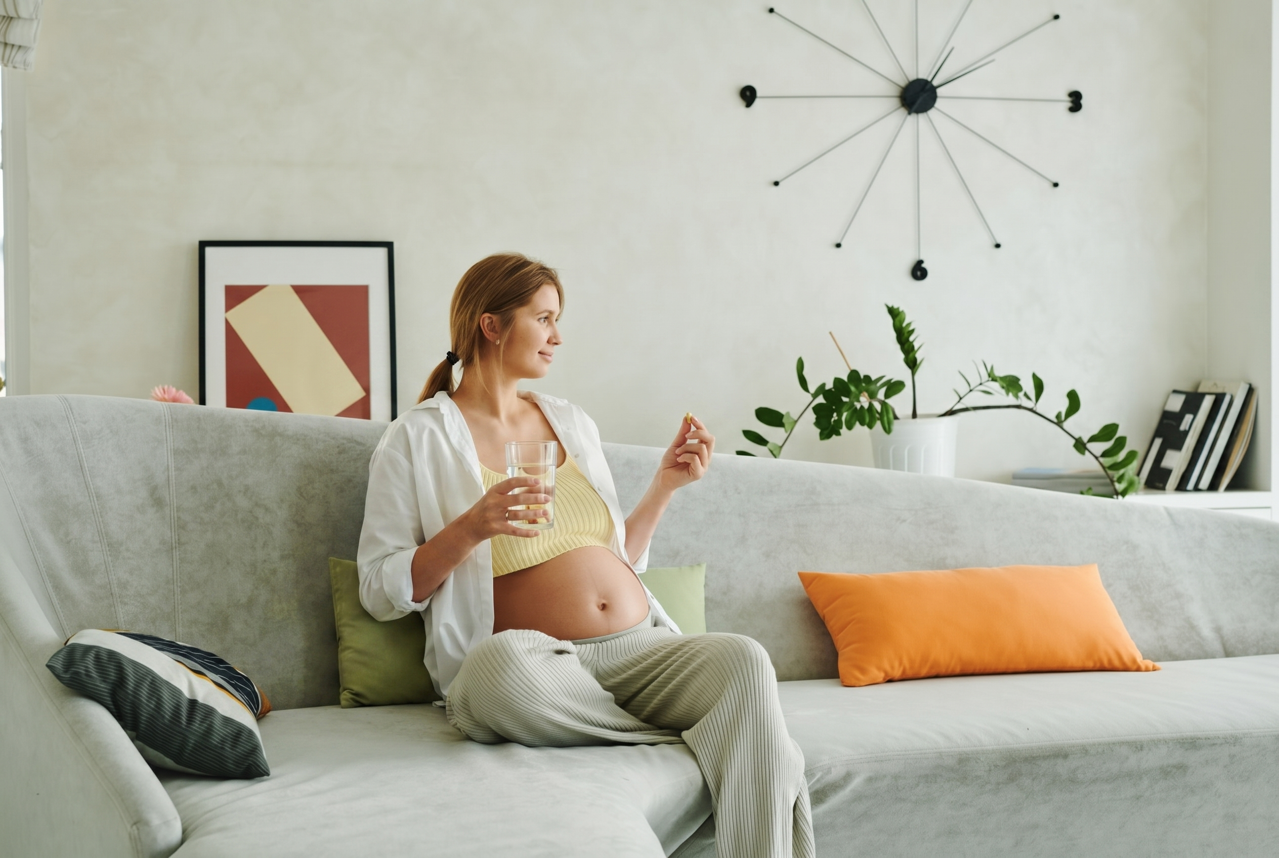 Schwangere Frau nimmt eine Vitamintablette